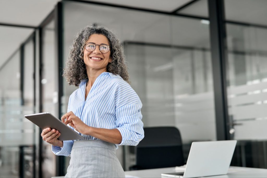 A business woman at work smiling in her new Neurolens glasses.