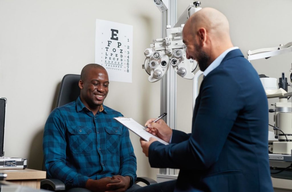 Smiling man discussing eye exam details with his optometrist