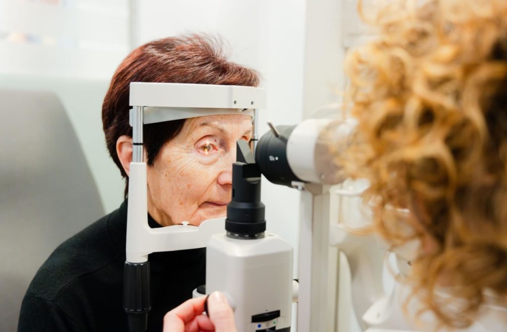 Senior woman undergoing an eye exam using specialized equipment to check for conditions like glaucoma or cataracts